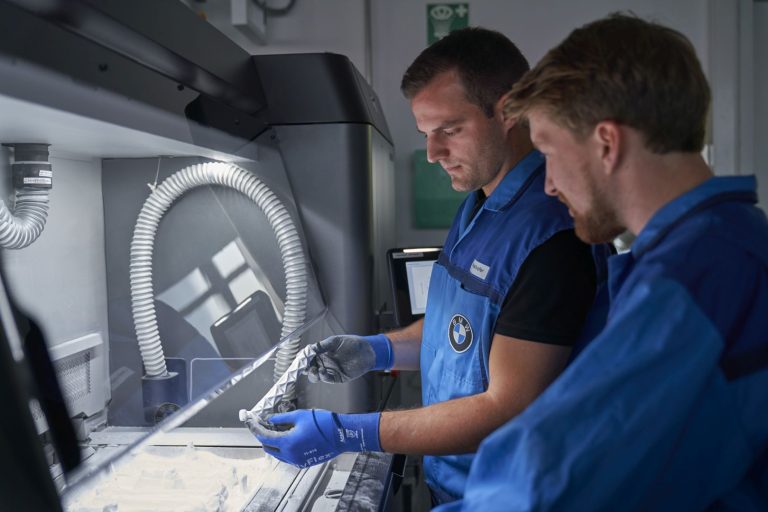 Removing powder material from 3d printed parts at BMW.